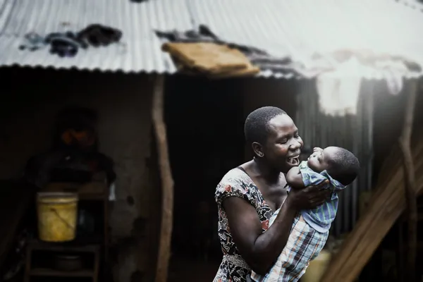 Mama akimbeba mtoto wake na kutabasamu jijini Arusha.