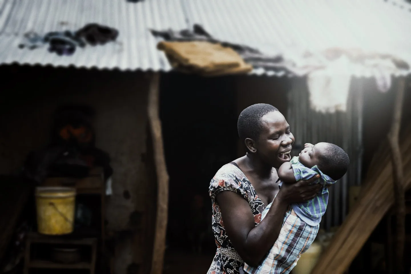 A mother lifting her baby and smiling in Arusha.