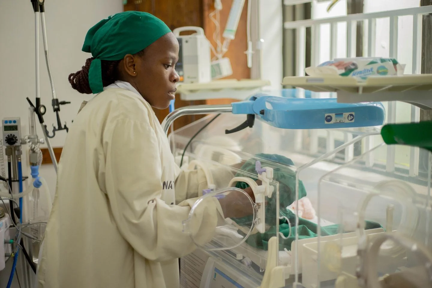Muuguzi akimhudumia mtoto mchanga ndani ya incubator hospitalini.