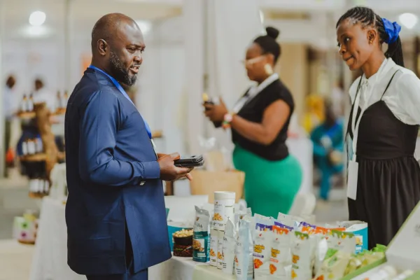 A salesman talks with visitors at a trade fair stand.