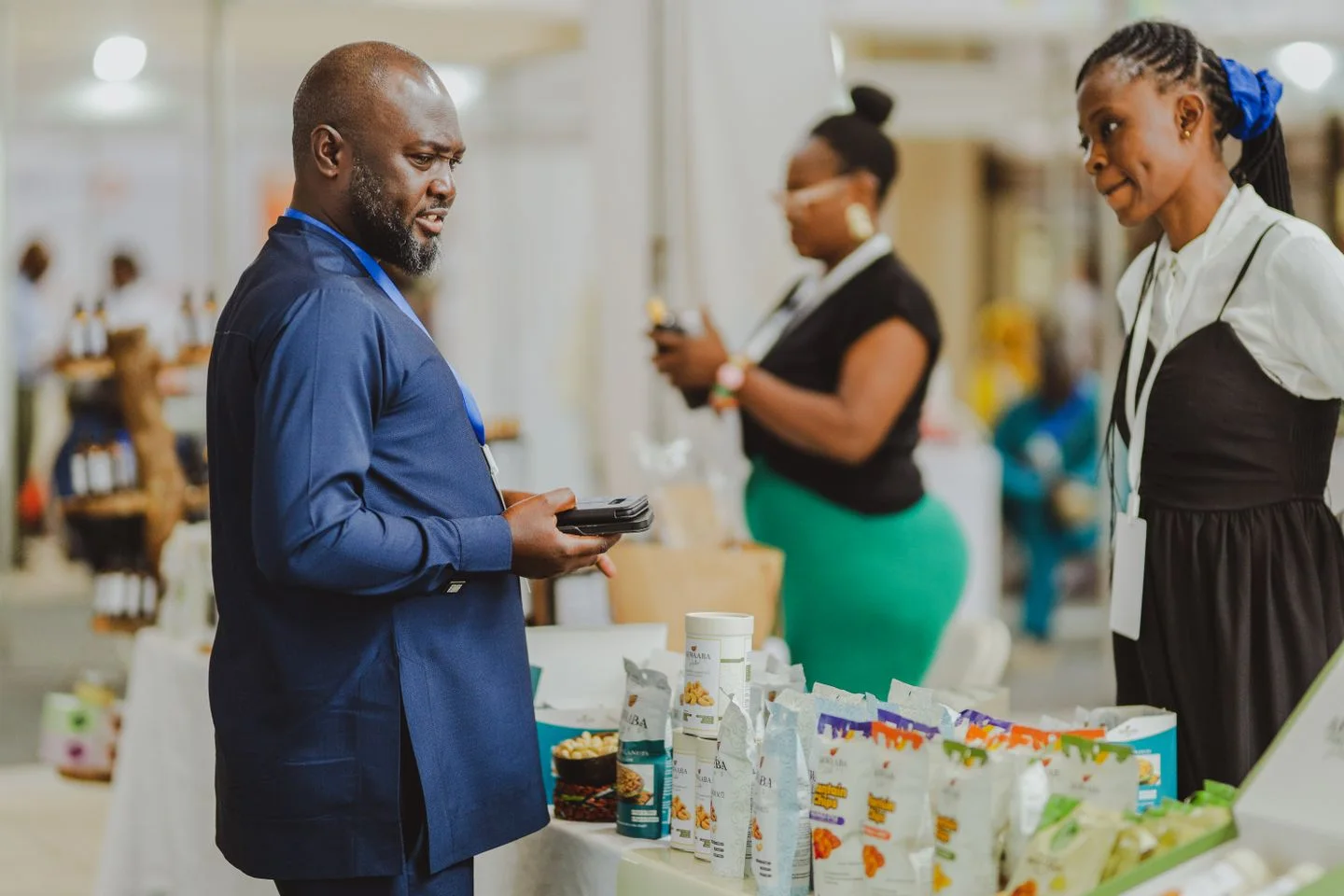 Muuzaji akizungumza na wageni kwenye banda la maonyesho ya biashara.