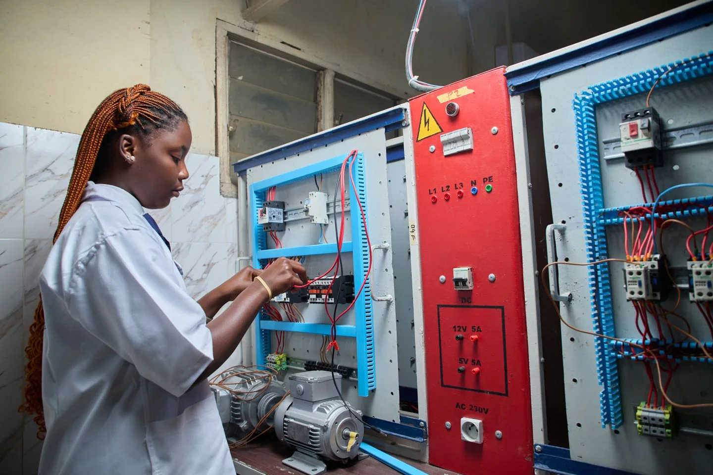 Fundi akipima nyaya kwenye paneli ya kudhibiti umeme.